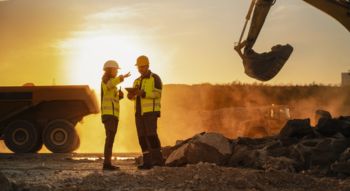 two members of a construction crew talking on site